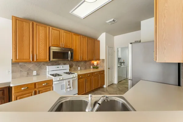 a kitchen with a sink a stove and cabinets