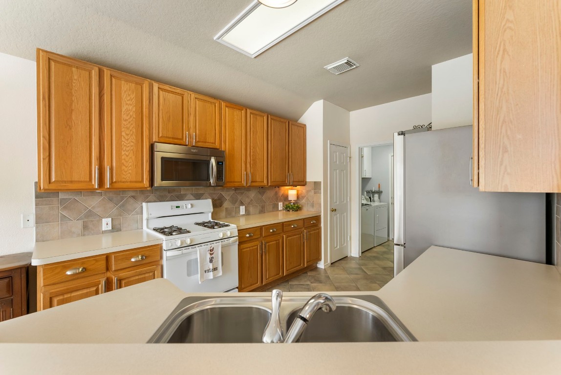 2015 Louetta Brook Court Spring, TX 77388 - Photo 7 of 28 a kitchen with a sink a stove and cabinets