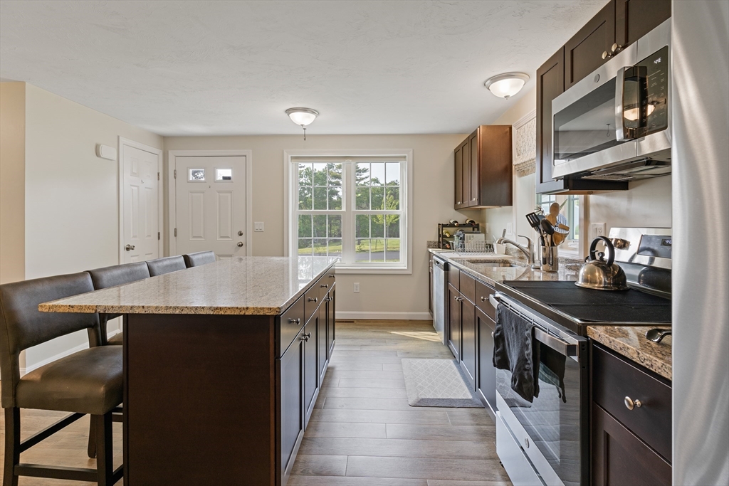 9 Tupper Hill Road, Unit 9 Plymouth, MA 02360 - Photo 12 of 30 a kitchen with stainless steel appliances granite countertop a sink a stove and a refrigerator