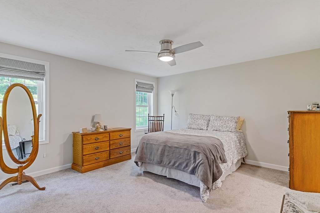 9 Tupper Hill Road, Unit 9 Plymouth, MA 02360 - Photo 23 of 30 a bedroom with a bed and a chandelier