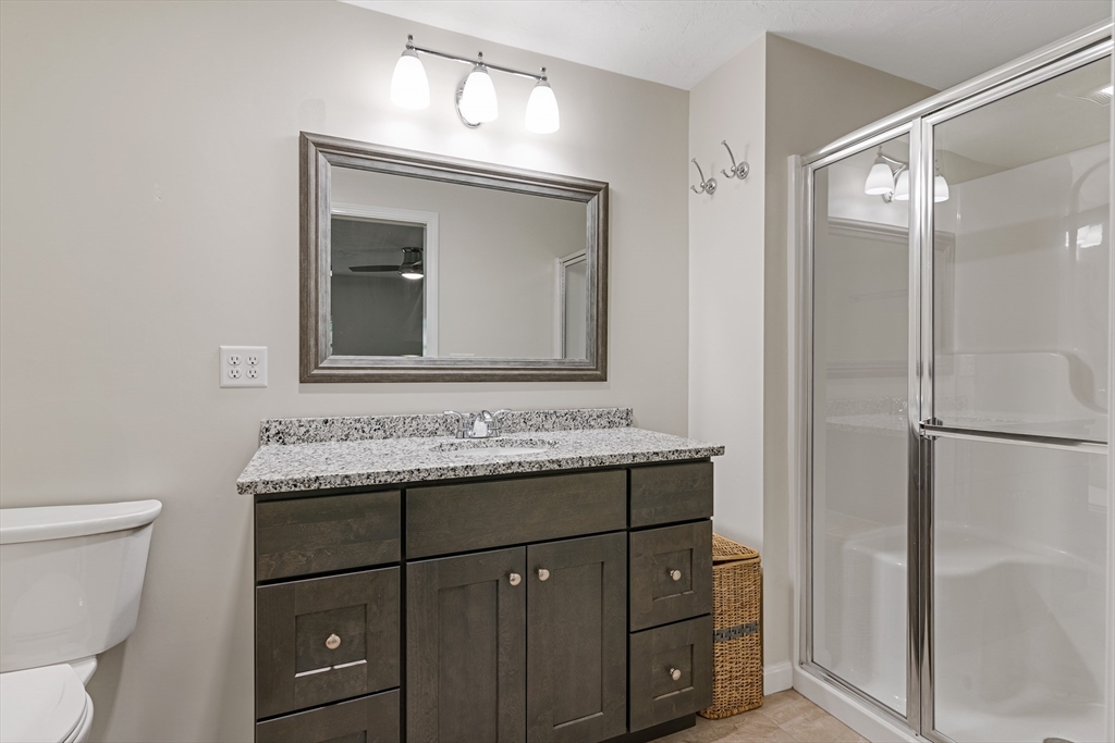 9 Tupper Hill Road, Unit 9 Plymouth, MA 02360 - Photo 25 of 30 a bathroom with a granite countertop sink toilet and mirror