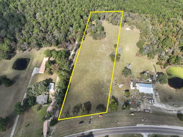 a view of a big yard with large trees