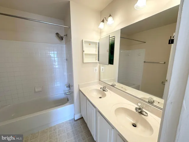 a bathroom with a tub sink and mirror