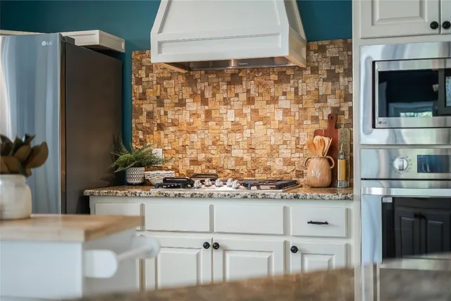 a kitchen with stainless steel appliances granite countertop a stove and a refrigerator