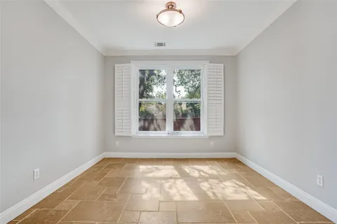 a view of a patio with a table and chairs under an umbrella with palm trees
