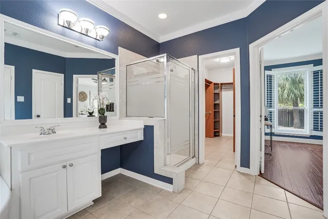 a spacious bathroom with a double vanity sink a mirror and a shower