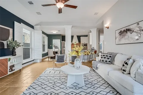 a view of an empty room with wooden floor and a ceiling fan