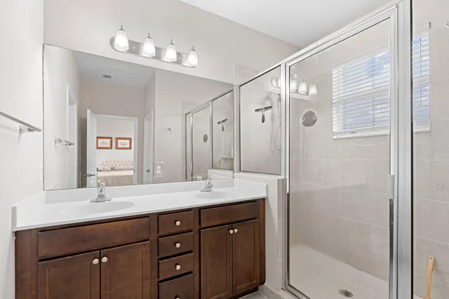 a bathroom with a shower sink vanity and mirror