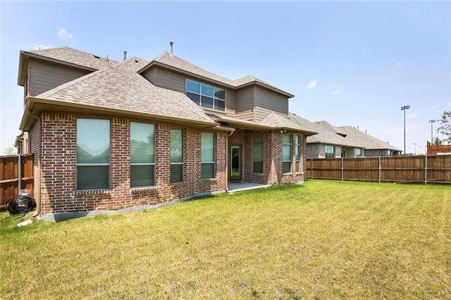 a view of a house with large windows and a small yard