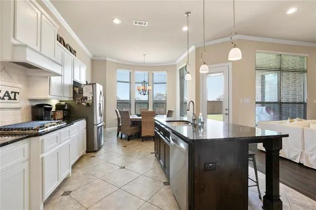 a kitchen with stainless steel appliances granite countertop a sink a stove and a refrigerator