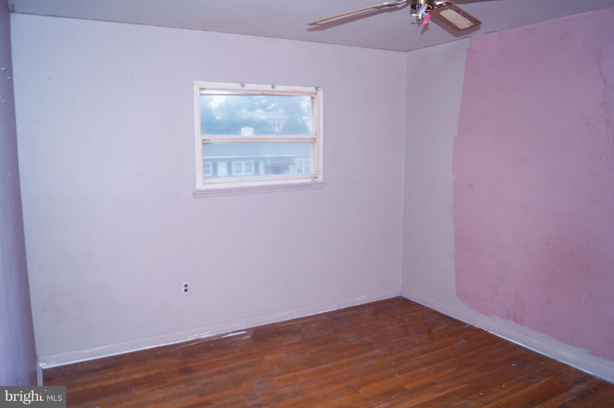 1319 Denbright Road Baltimore, MD 21228 - Photo 6 of 11 a view of an empty room with wooden floor and a window
