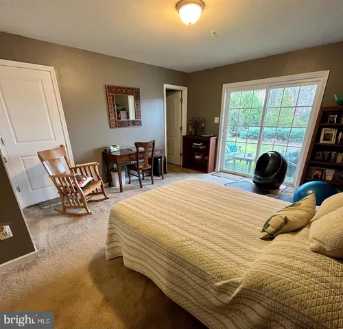 a bedroom with a bed a large window and walk in closet