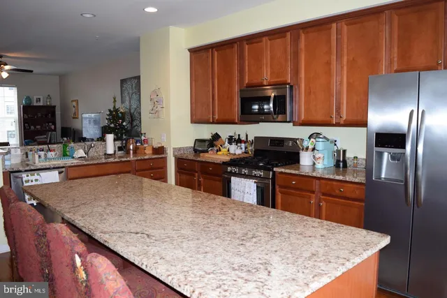 a kitchen with stainless steel appliances granite countertop wooden cabinets a stove top oven a sink and dishwasher