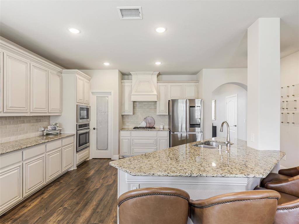 1216 Tree Shadow Lane Anna, TX 75409 - Photo 6 of 37 a kitchen with stainless steel appliances granite countertop a sink refrigerator and cabinets