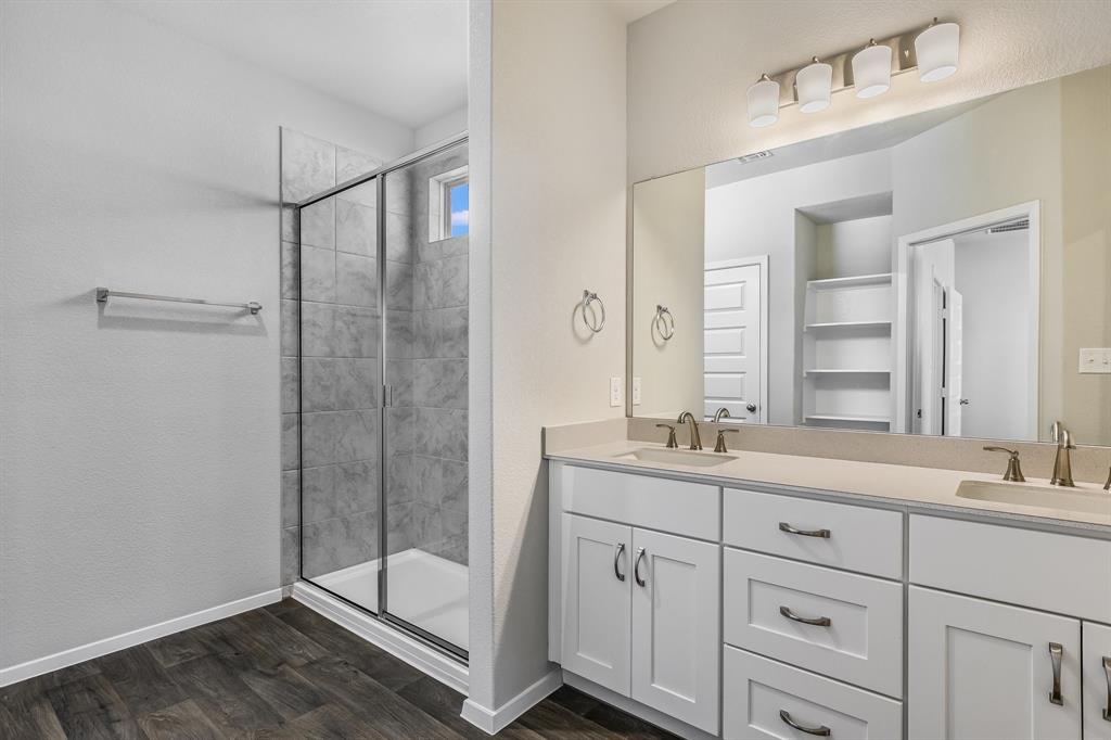 2808 Totley Road Manor, TX 78653 - Photo 9 of 21 Bathroom featuring a dual vanity with white cabinetry, light-toned countertops, and brushed nickel hardware