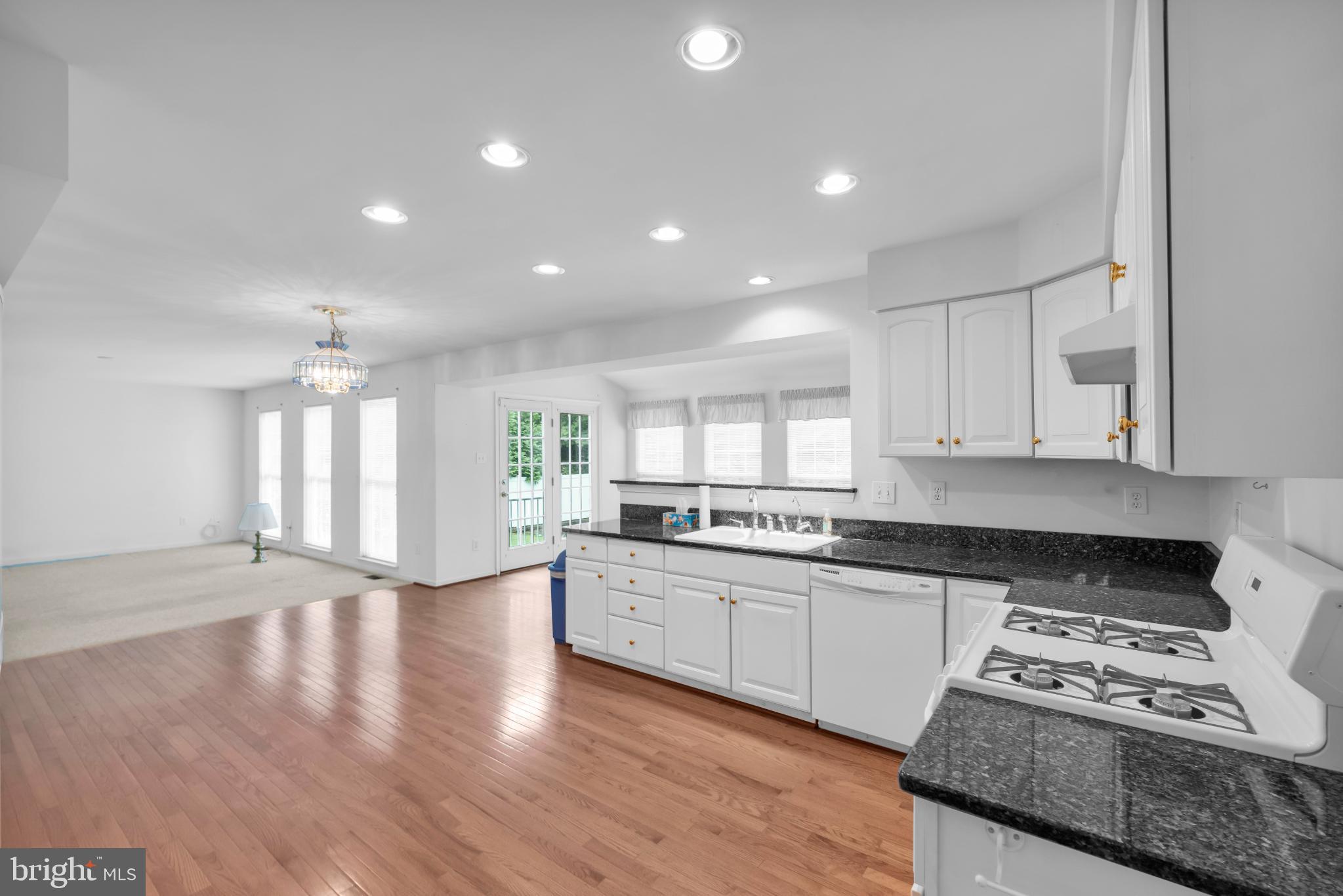 5184 Lovering Drive Doylestown, PA 18902 - Photo 7 of 51 a kitchen with granite countertop a stove and white cabinets with wooden floor