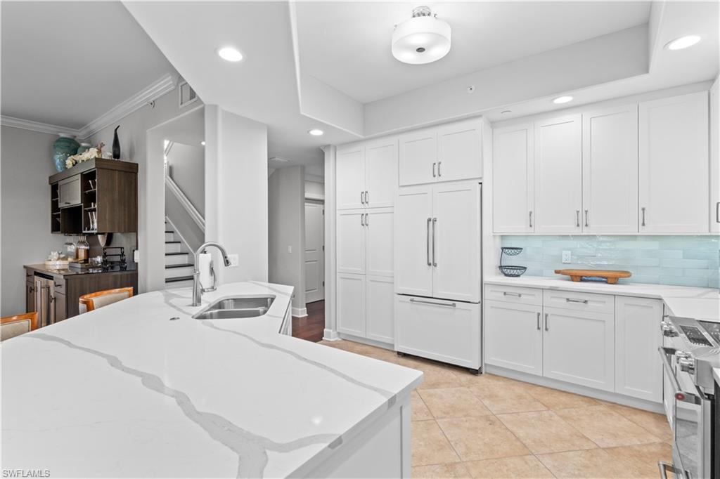 1104 6th Street South, Unit 1 Naples, FL 34102 - Photo 11 of 40 Kitchen featuring light stone counters, paneled refrigerator, white cabinetry, stainless steel electric range oven, and recessed lighting