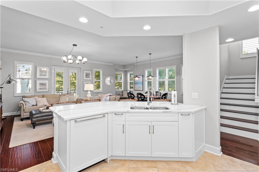1104 6th Street South, Unit 1 Naples, FL 34102 - Photo 39 of 40 Kitchen featuring white cabinetry, a peninsula, open floor plan, pendant lighting, and light stone countertops