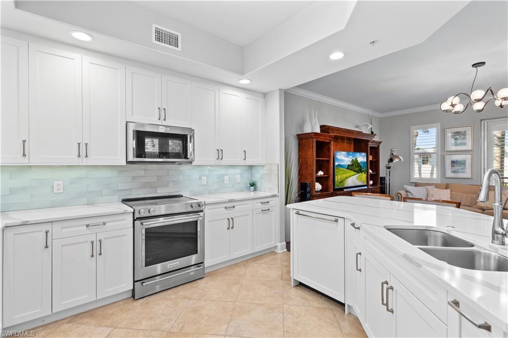 1104 6th Street South, Unit 1 Naples, FL 34102 - Photo 40 of 40 Kitchen with white cabinets, stainless steel appliances, ornamental molding, open floor plan, and recessed lighting