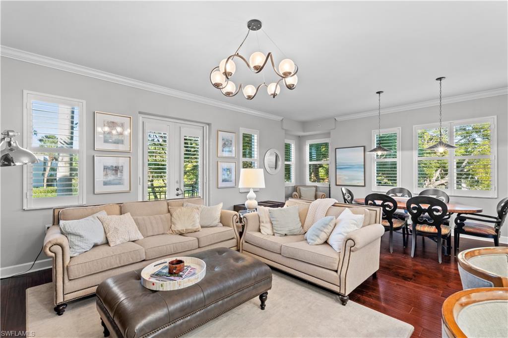 1104 6th Street South, Unit 1 Naples, FL 34102 - Photo 13 of 40 Living room featuring a chandelier, healthy amount of natural light, dark wood-style floors, and ornamental molding