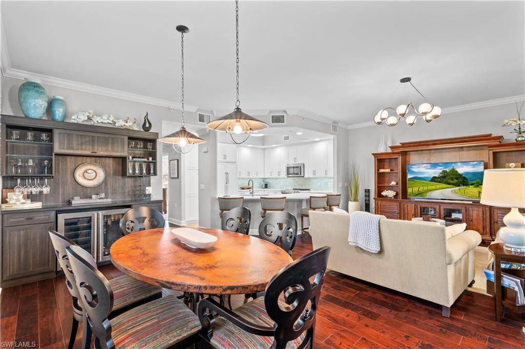 1104 6th Street South, Unit 1 Naples, FL 34102 - Photo 16 of 40 Dining space with crown molding, dark wood-style flooring, a dry bar, a chandelier, and wine cooler