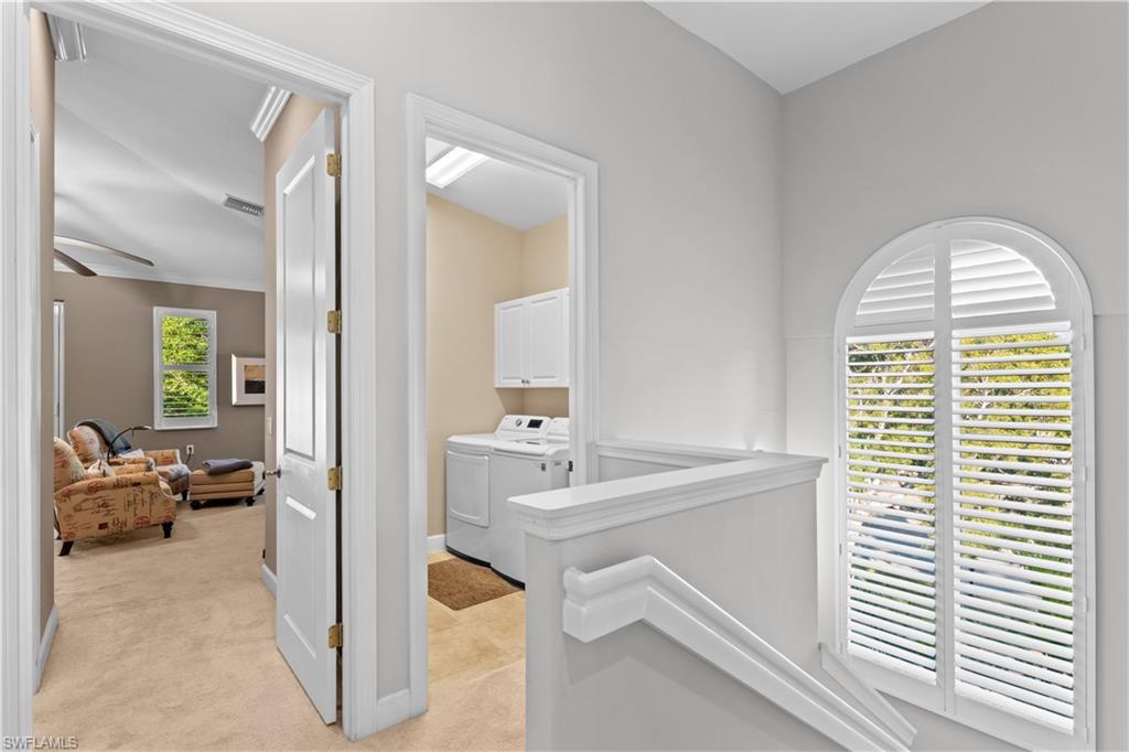1104 6th Street South, Unit 1 Naples, FL 34102 - Photo 21 of 40 Corridor featuring light colored carpet, washing machine and clothes dryer, and an upstairs landing