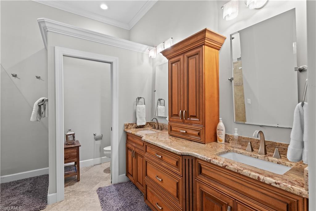 1104 6th Street South, Unit 1 Naples, FL 34102 - Photo 28 of 40 Bathroom with double vanity, ornamental molding, and light tile patterned floors