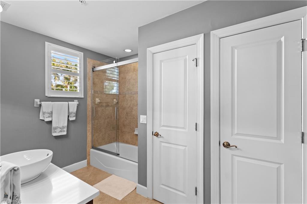 1104 6th Street South, Unit 1 Naples, FL 34102 - Photo 32 of 40 Full bath featuring vanity, bath / shower combo with glass door, light tile patterned flooring, and recessed lighting
