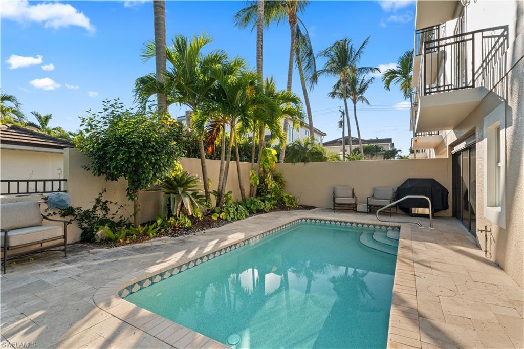 1104 6th Street South, Unit 1 Naples, FL 34102 - Photo 8 of 40 View of swimming pool featuring a patio area, a fenced backyard, and a balcony