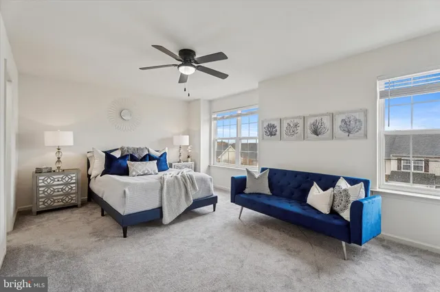 a spacious bedroom with a bed couch and window