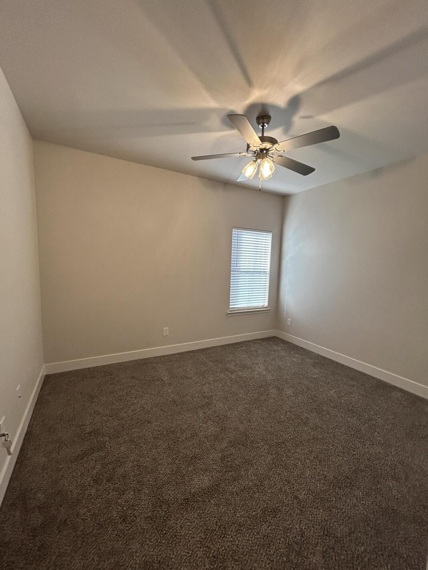 6906 18th Street Lubbock, TX 79416 - Photo 12 of 14 an empty room with windows fan and a ceiling fan