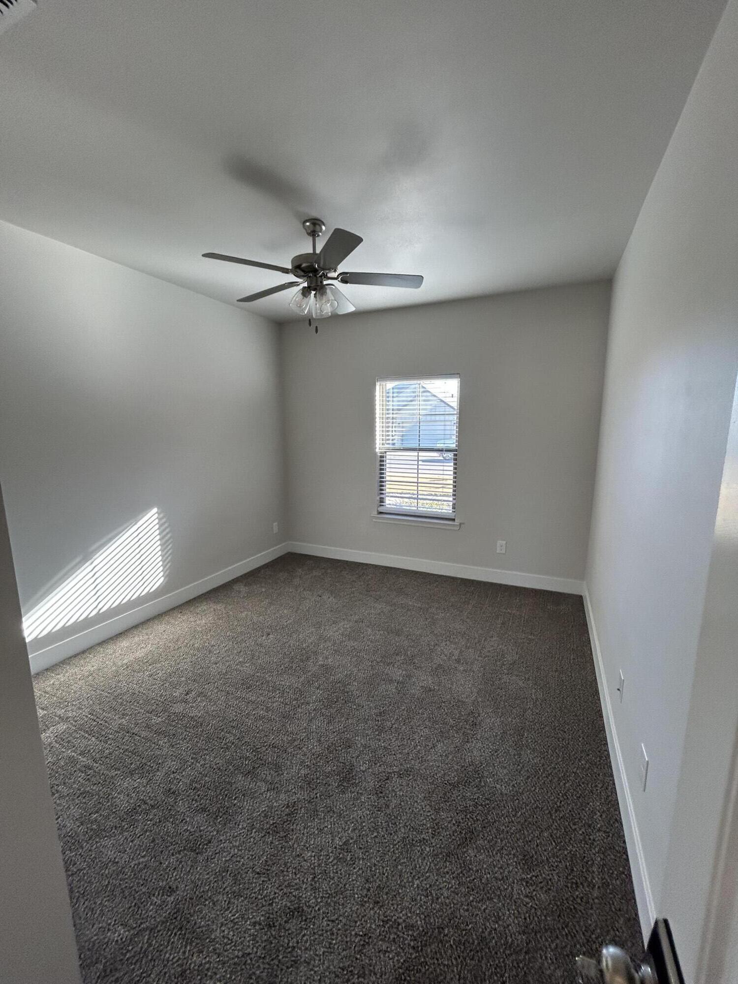 6906 18th Street Lubbock, TX 79416 - Photo 13 of 14 an empty room with windows and fan