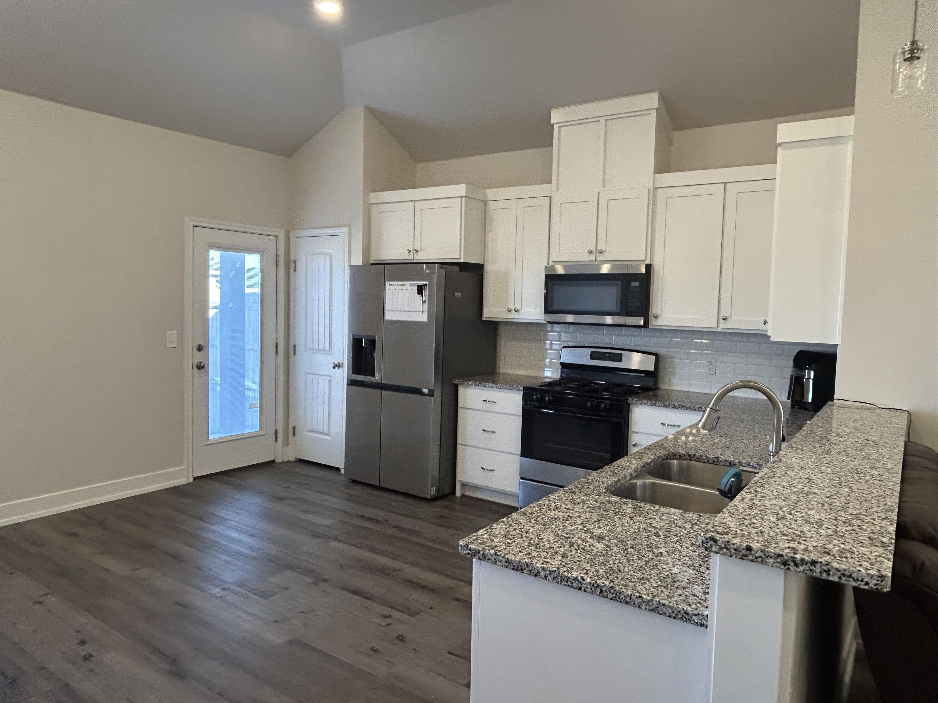 6906 18th Street Lubbock, TX 79416 - Photo 6 of 14 a kitchen with granite countertop stainless steel appliances and wooden cabinets