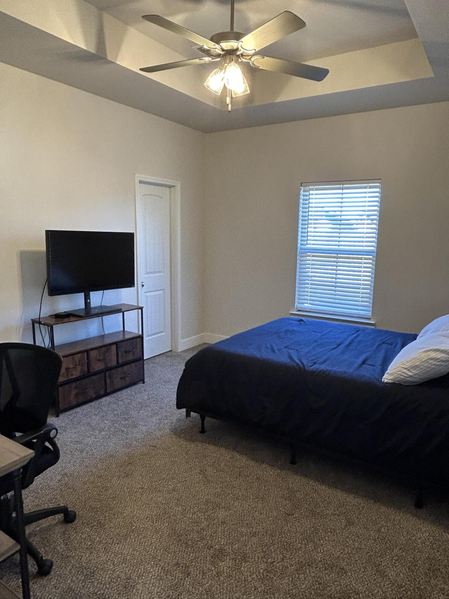 6906 18th Street Lubbock, TX 79416 - Photo 7 of 14 a bedroom with a bed and a flat screen tv