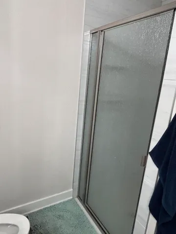 a bathroom with a glass shower door