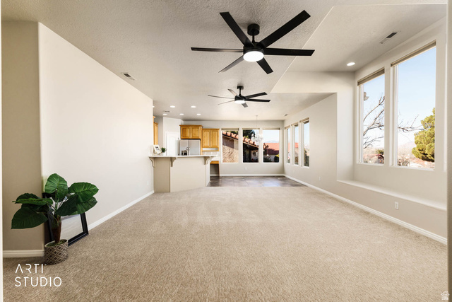 2158 Balboa Way St. George, UT 84770 - Photo 6 of 40 Unfurnished living room with light colored carpet, recessed lighting, a textured ceiling, and ceiling fan