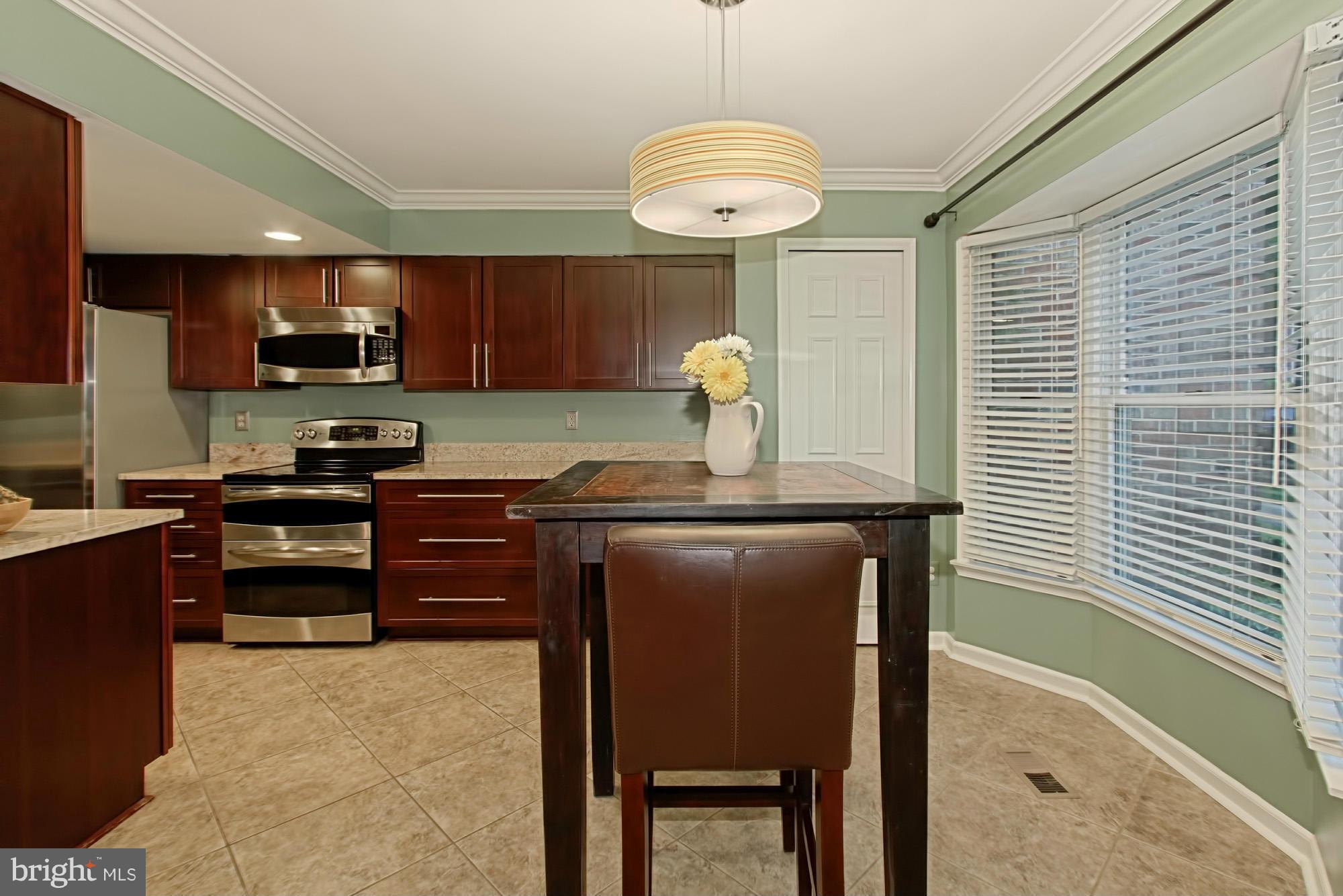 6271 Rathlin Drive Springfield, VA 22152 - Photo 3 of 29 a kitchen with kitchen island granite countertop a sink cabinets and stainless steel appliances