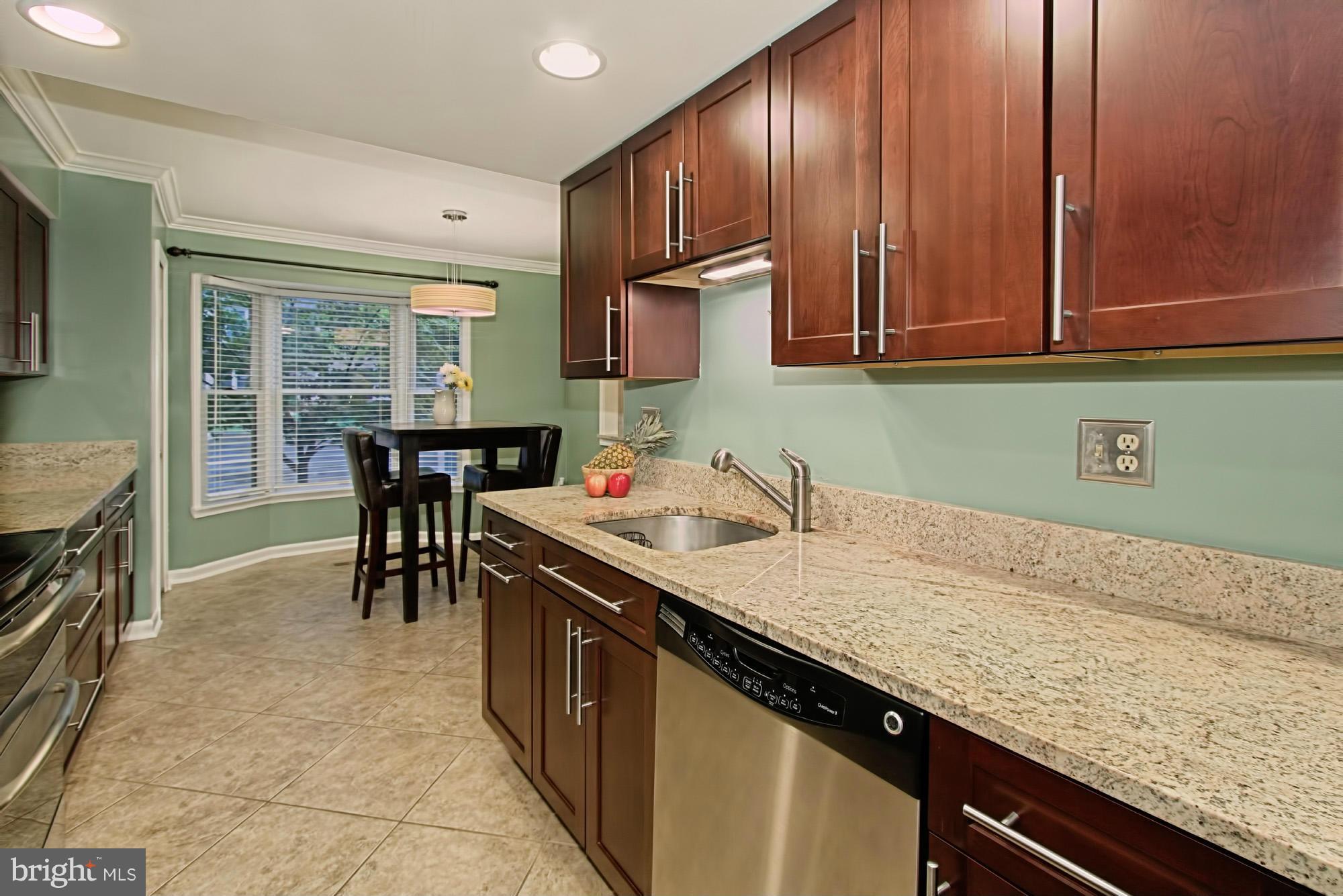 6271 Rathlin Drive Springfield, VA 22152 - Photo 7 of 29 a kitchen with granite countertop sink stove and cabinets