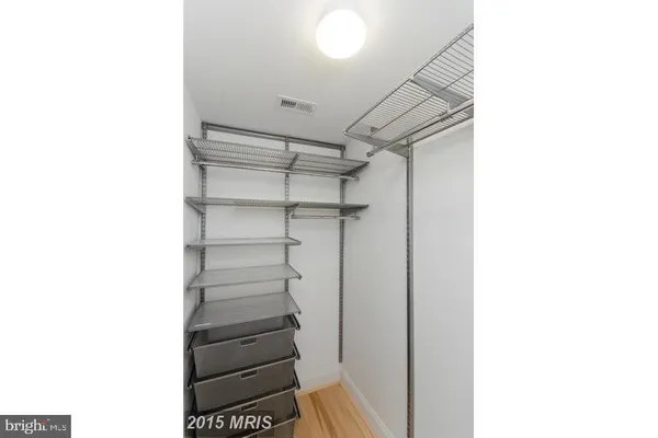 a view of walk in closet with empty racks