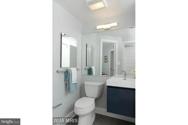 a bathroom with a toilet a sink a mirror and a shower