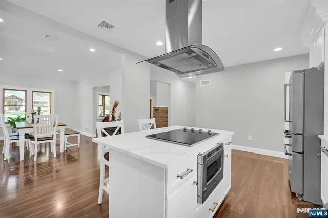 a kitchen that has a lot of cabinets in it and wooden floors