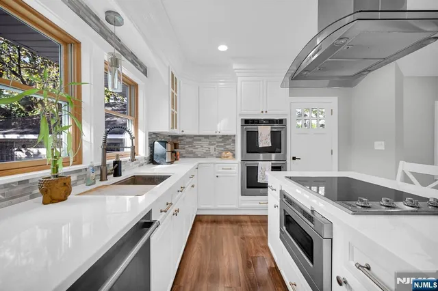 a kitchen with a sink a counter top space stainless steel appliances and a large window