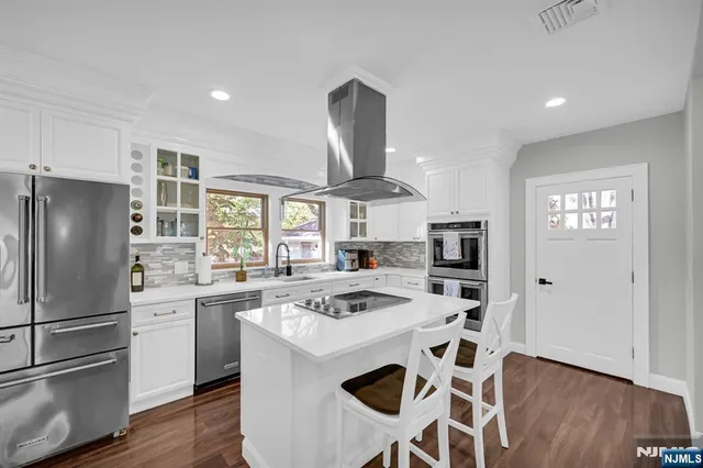 a kitchen with stainless steel appliances granite countertop a stove a refrigerator and a refrigerator