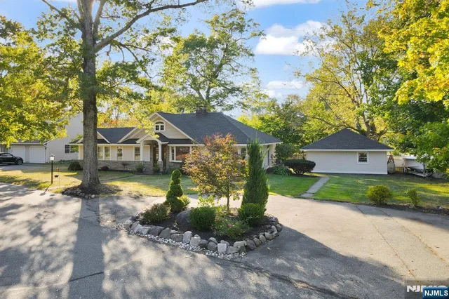a front view of a house with a yard and lake view