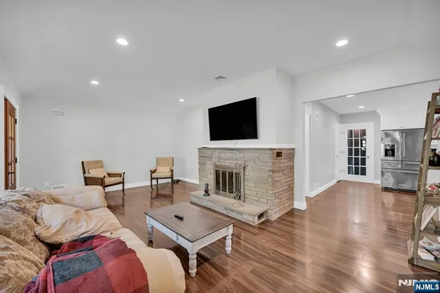 a living room with furniture a flat screen tv and a fireplace