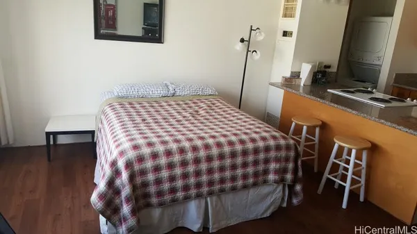 a bedroom with a bed and a flat tv screen on the dresser