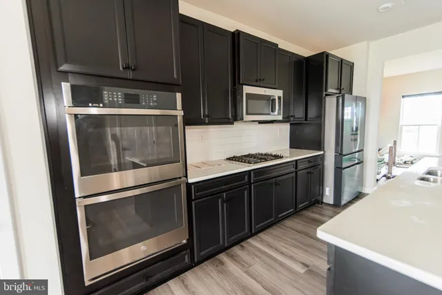 a kitchen with granite countertop stainless steel appliances and wooden cabinets