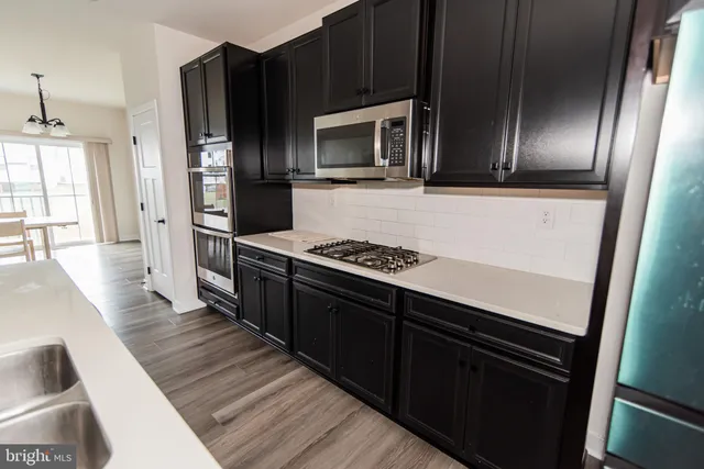 a kitchen with stainless steel appliances granite countertop a refrigerator and a stove top oven