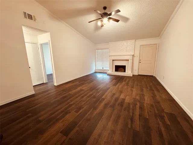 a view of empty room with wooden floor and fireplace
