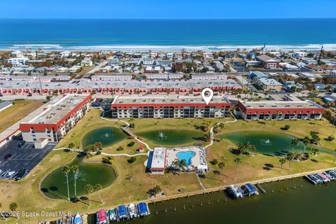 an aerial view of a city with lots of residential buildings ocean and mountain view in back